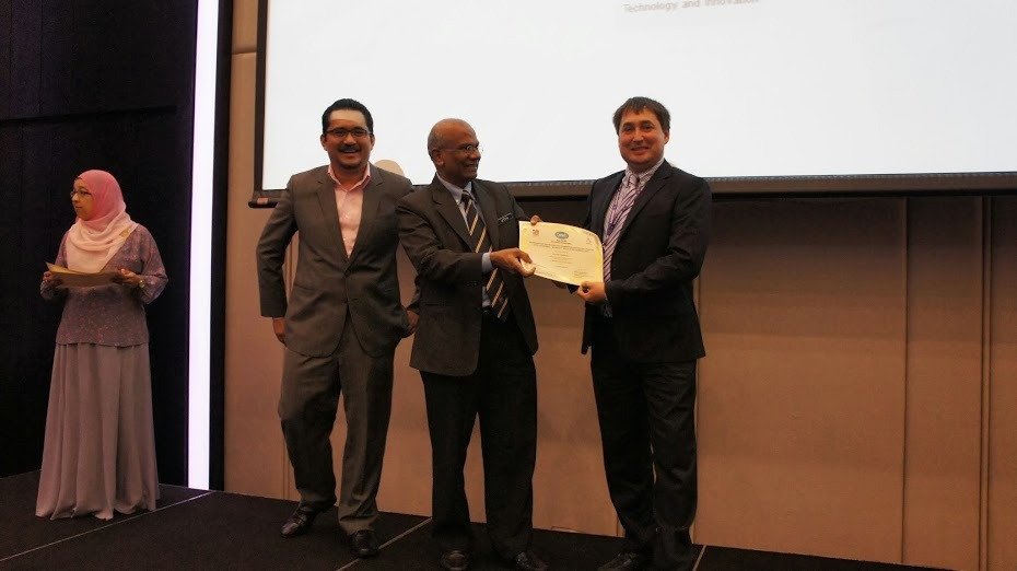 Эдуард Шуралев принимает поздравления и получает сертификат от Letchumanan Ramatha (директор Департамента биобезопасности Министерства природных ресурсов и окружающей среды Малайзии) и Adrian Abdul Ghani (BioNexus Development Division, Malaysian Biotechnology Corp. Sdn. Bhd., Малайзия).